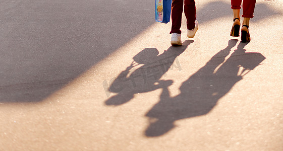 上学的女人的母亲和儿子的孩子的影子和腿的一部分。
