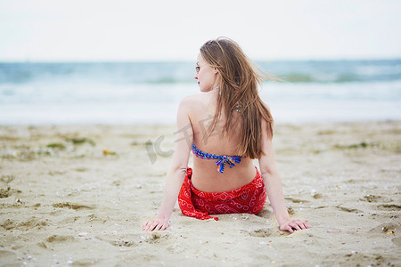 美丽的年轻女子在海滩上放松和晒日光浴