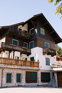 位于意大利北部多洛米蒂山脉、科尔蒂纳安佩佐镇冬季滑雪胜地的一栋粉刷成白色的白色房子，采用木制元素。