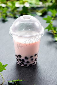 波巴摄影照片_在塑料杯中用牛奶和木薯珍珠泡泡波巴茶