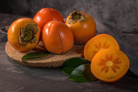 柿子果实摄影照片_软木盘中成熟的柿子果实