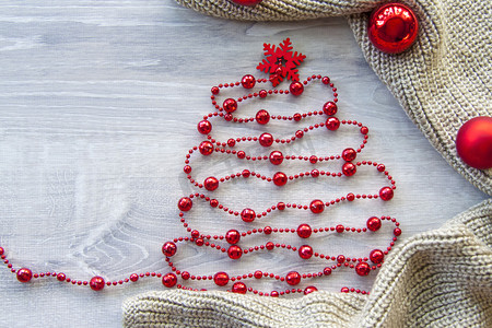 喜庆大红摄影照片_圣诞树由珠子制成，上面有大红色雪花而不是星星。