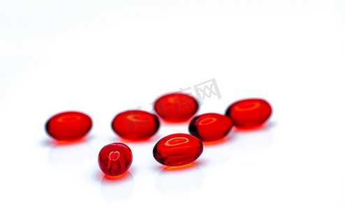口服胶原蛋白摄影照片_在白色背景上分离的红色软凝胶胶囊药丸。