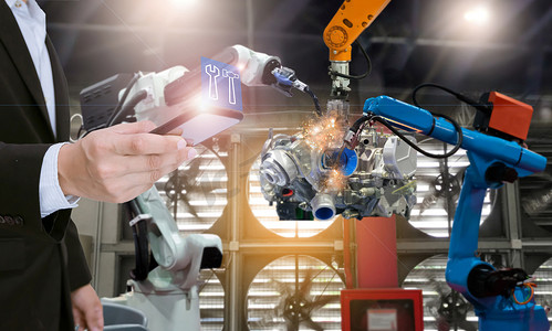 具有智能手机控制自动化机器人的系统工程师装备工厂零件发动机制造业机器人和机械臂的生产