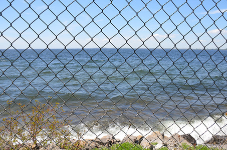 有海水和天空的金属链环围栏