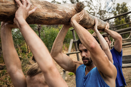 人们在新兵训练营期间举起沉重的木头
