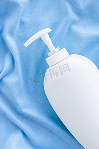 蓝色丝绸、卫生用品和保健品上抗菌液体肥皂和洗手液模型的空白标签瓶