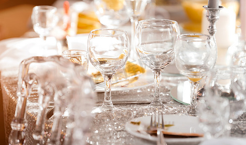 美丽的节日餐桌上摆满了豪华盘子、玻璃杯和餐具，供品酒使用。