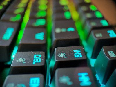 带有霓虹灯背光宏的游戏玩家键盘离焦特写。