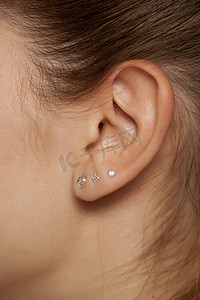 女性耳朵与三个耳环