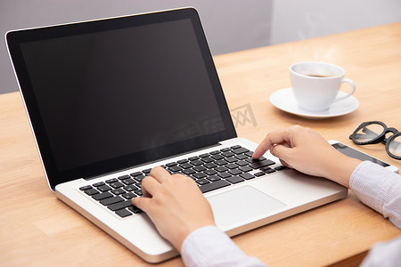 女黑色摄影照片_女商人使用笔记本电脑，使用手指与键盘打字。