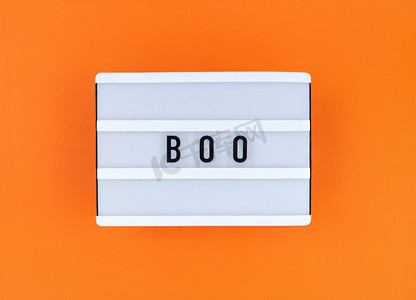 圣字摄影照片_橙色背景上有 Boo 字的灯箱。