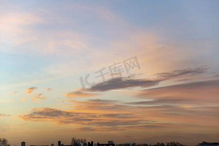 渐变蓝色大气摄影照片_清晨天空的肖像，地平线上生动的早晨日出照亮了锡和小云