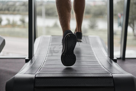 无法辨认的男子跑步跑步机健身房运动员慢跑室内减肥锻炼慢跑者跑灰色墙壁背景有氧训练