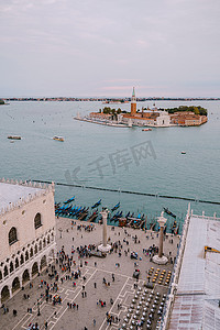 10月10日摄影照片_意大利威尼斯 — 2019年10月4日：从圣马可广场附近的贡多拉主码头上巨大的大教堂钟楼圣马可钟楼鸟瞰，圣乔治马焦雷是最著名的岛屿之一