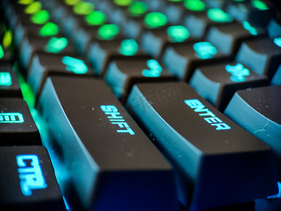 游戏钥匙摄影照片_带有霓虹灯背光宏的游戏玩家键盘离焦特写。