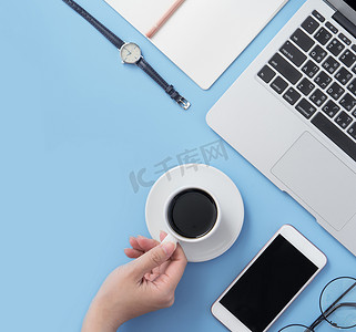 自由职业者博客作家女性在干净的浅蓝色桌子上喝咖啡放松，在家工作概念，复制空间，平躺，顶视图，模型