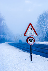 有交通标志的多雪的路和在乡下公路的大雪。