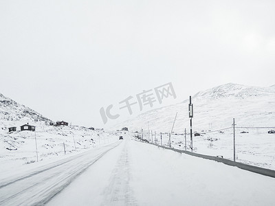 挪威人摄影照片_开车穿过雪路和风景，挪威。