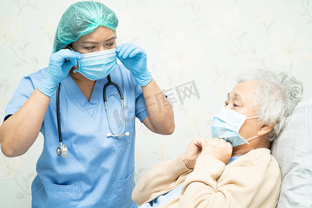 医生在医院为戴口罩的亚洲老年女患者提供技术，以保护 Covid-19 冠状病毒。
