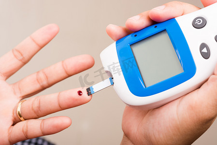 测量血糖测试水平的妇女用手指上的血液进行检查