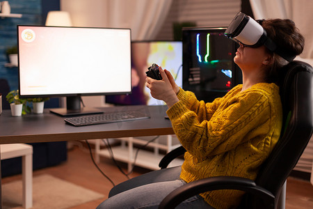 网络游戏摄影照片_使用虚拟现实耳机玩网络游戏的女性电子竞技网络游戏