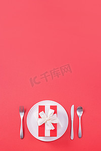 餐食摄影照片_情人节餐食设计理念-浪漫的盘菜以红色背景为特色，适合餐厅、节日庆典促销、顶视图、平躺。