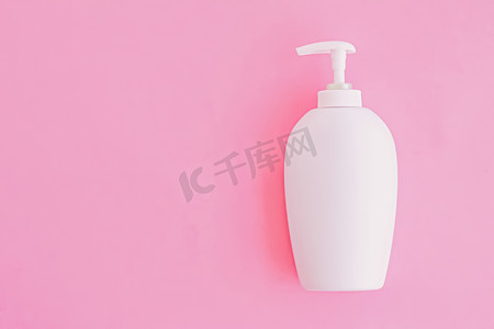 粉红色背景的一瓶抗菌液体皂和洗手液、卫生用品和保健品