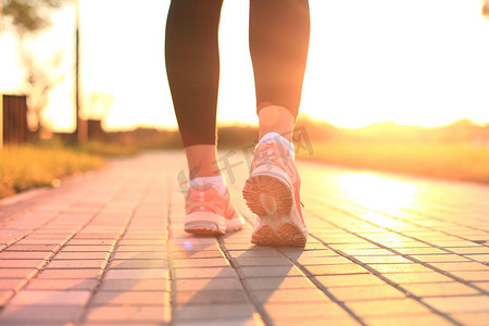 跑步者的脚在城市日落或日出时在户外的鞋子上特写地跑步