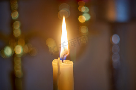 蜡烛火焰在夜间与深色背景上的散景。