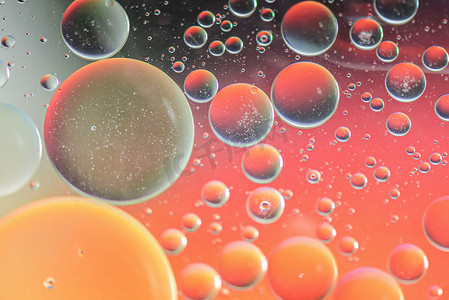 用油、水和肥皂制作的红色和橙色抽象离焦背景图片