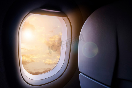 从飞机窗户看到的云彩和天空，金色的阳光和镜头光晕