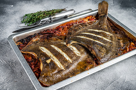 鲽鱼或比目鱼扁鱼在烤盘中用番茄酱烘烤。