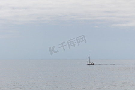一艘白色的小船驶过平静的海面