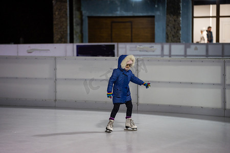滑冰孩子摄影照片_小女孩在溜冰场学习滑冰