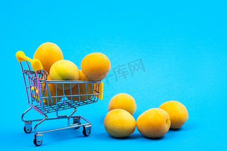 蓝色背景上有杏子的购物篮。购物车