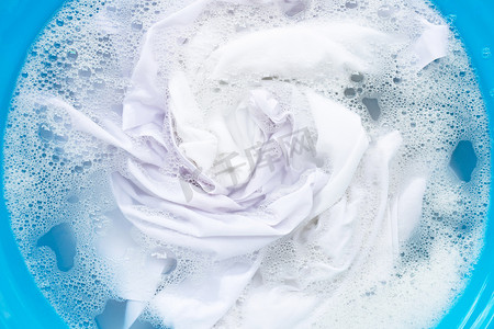 白色衣物浸泡在洗衣粉水中溶解。