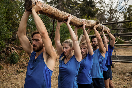 人们在新兵训练营期间举起沉重的木头