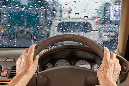雨季，老妇人在城市里慢慢开车