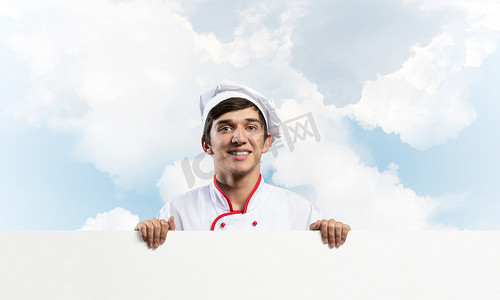 餐饮横幅摄影照片_有空白的牌的年轻男性厨师