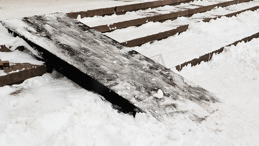 积雪覆盖着湿滑的混凝土楼梯和木制坡道。