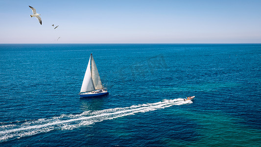 孤立在蓝色海水中的白色帆船。