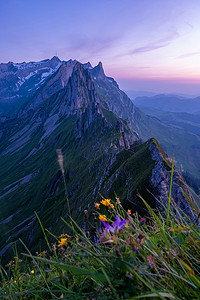 阿斯哈图石林摄影照片_山中的日落，舍弗勒 Altenalptuerme 山脊瑞士阿尔卑斯坦高山阿彭策尔内罗登瑞士，瑞士阿尔卑斯坦山雄伟舍弗勒峰的陡峭山脊