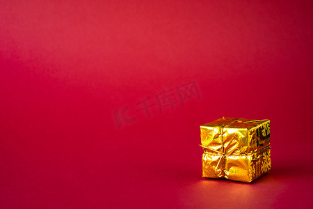 红色背景上的金色节日礼品盒。