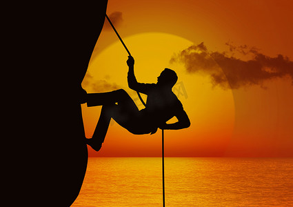 攀登剪影夕阳摄影照片_用绳子攀登悬崖的人的剪影