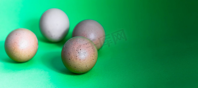 复活节的抽象图片，四个鸡蛋不在绿色背景的一个锐度平面上，从左到右变暗