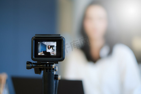 博客摄影照片_女商人或博主在数码相机和直播上录制视频博客。