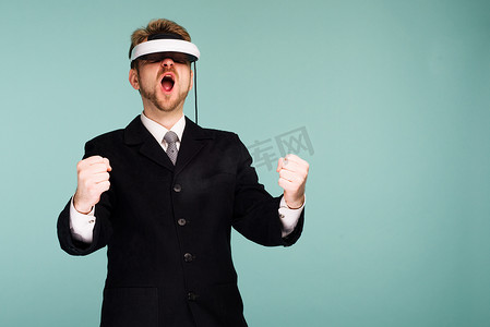 穿着正装的商人戴着虚拟现实眼镜，拿着虚拟方向盘