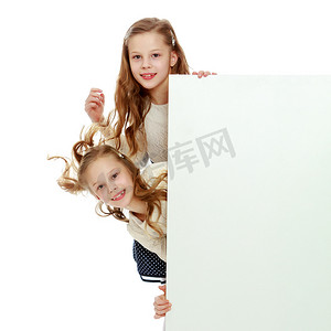 两个小女孩从白色广告禁令后面偷看