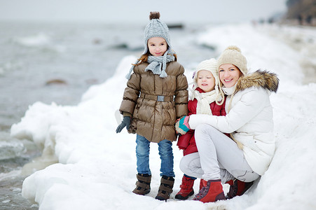 母亲和她的女儿们在冬天海边
